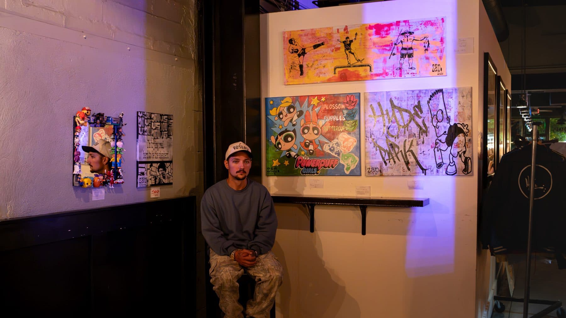 The artist seated in front of the work