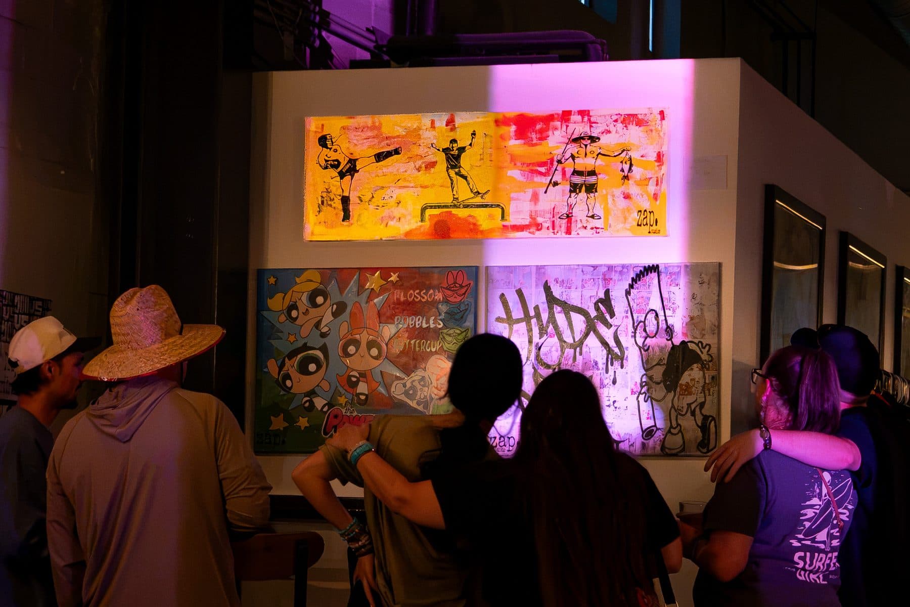 Visitors in front of the wall at the group show